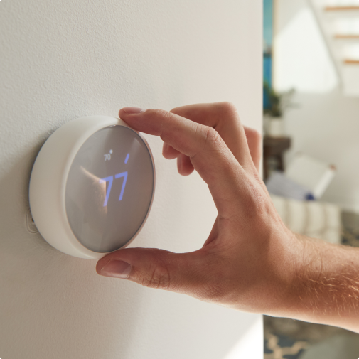 person adjusting smart thermostat